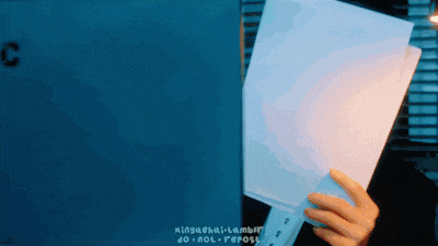 a person is holding a piece of paper in front of a sign that says c.