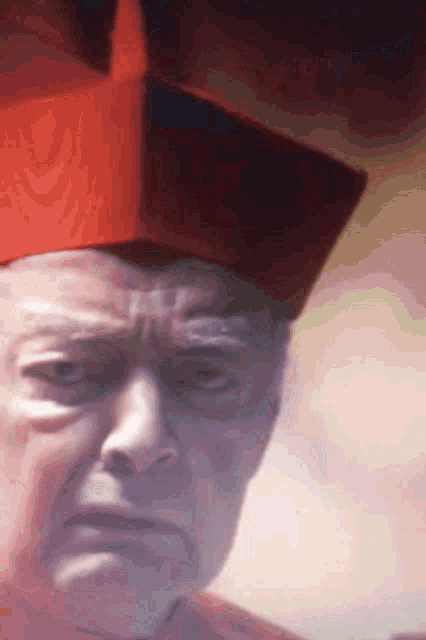 a close up of a man 's face with a red hat on his head