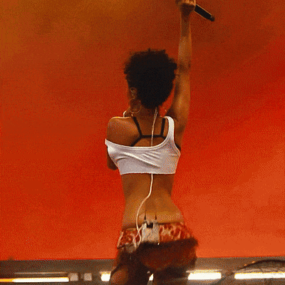 a woman in a crop top is holding a microphone