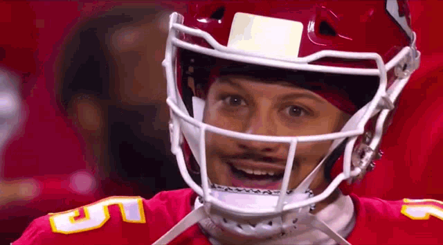 a football player wearing a helmet and a red jersey is smiling .