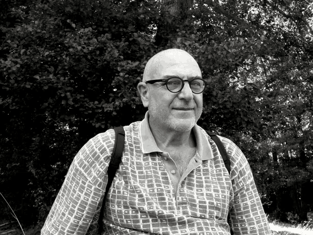 a man wearing glasses and a shirt with a pattern of squares