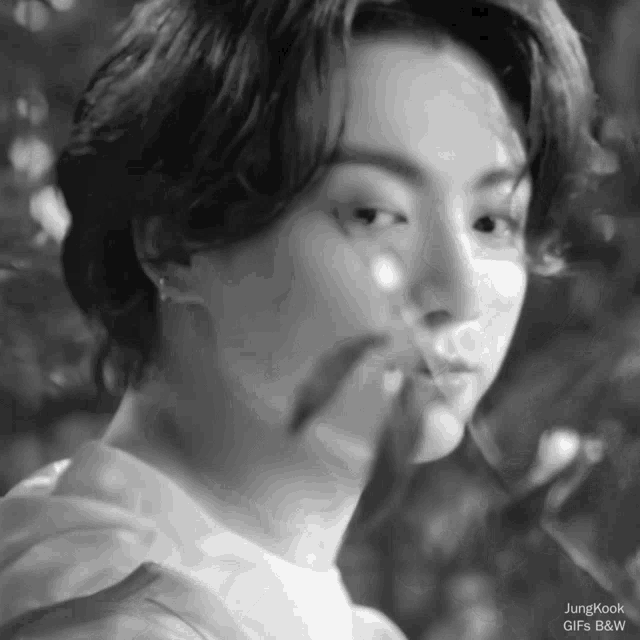 a black and white photo of a young man 's face .