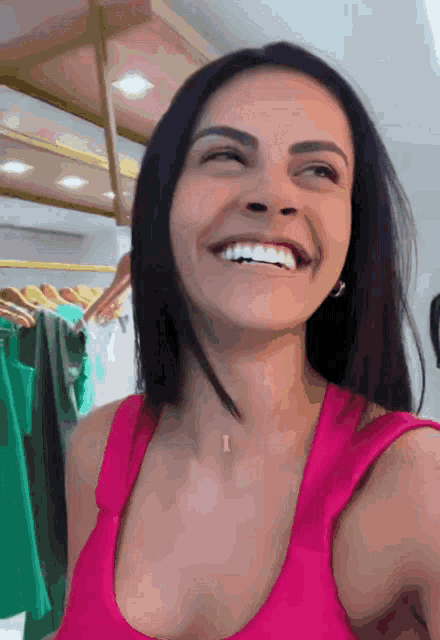 a woman in a pink tank top with the letter i on her neck is smiling