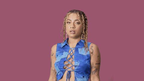 a woman with tattoos on her arms and chest is wearing a blue top