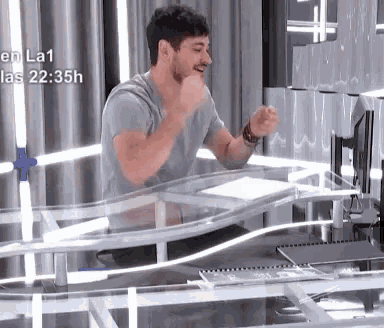a man sitting at a desk with the time 22:35 on the bottom