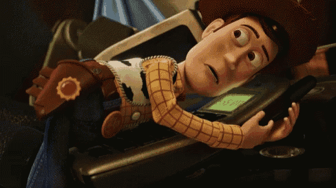 a toy story character laying on a table holding a cell phone