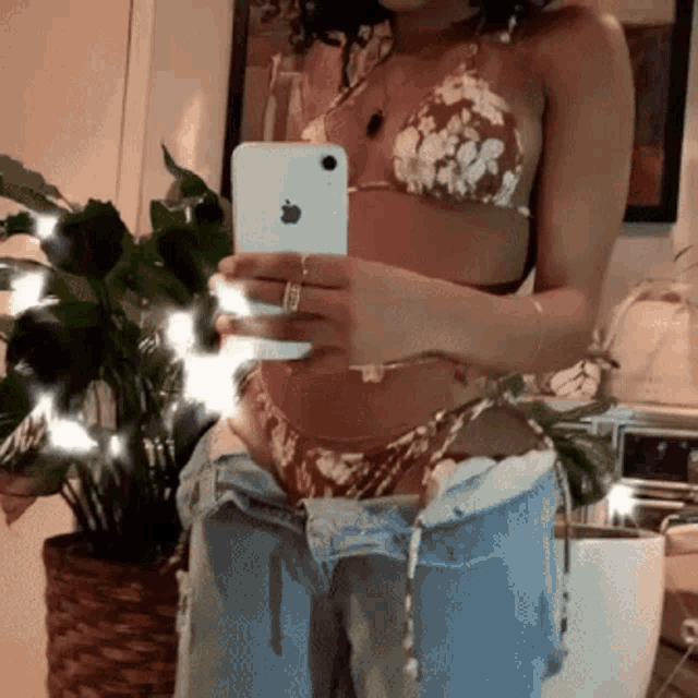 a woman in a bikini is taking a picture of herself