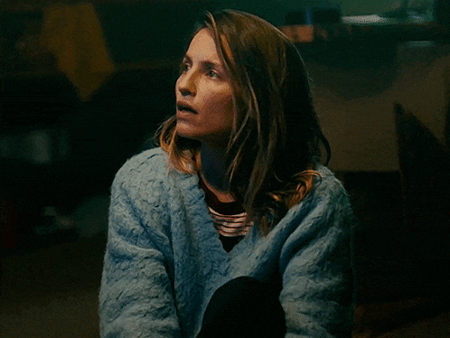 a woman in a blue sweater is sitting down