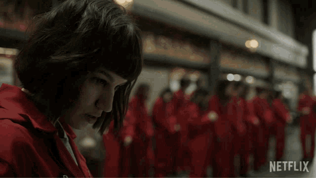 a woman in a red jacket is standing in front of a netflix sign