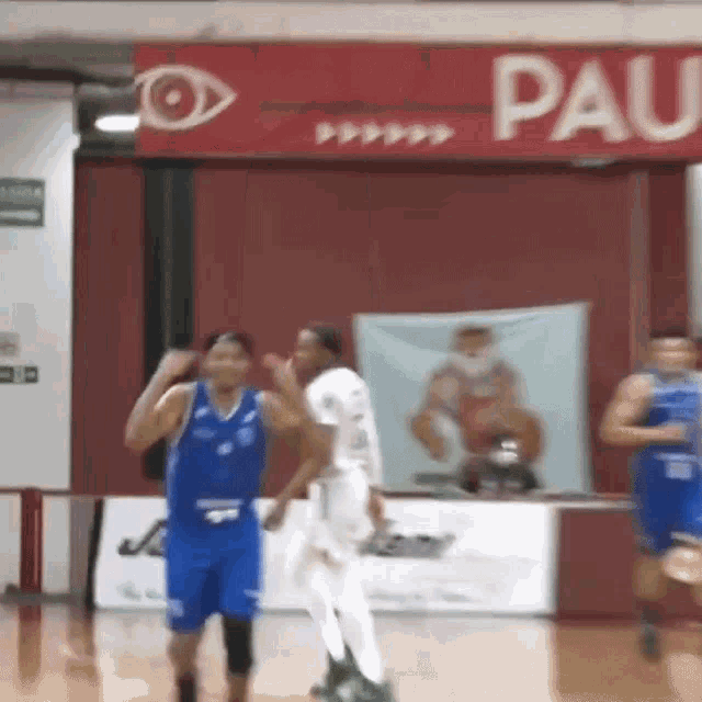 basketball players on a court in front of a sign that says paul