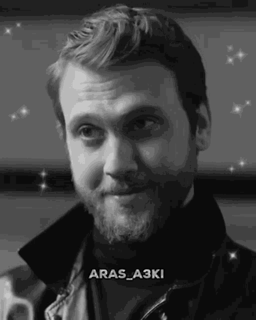 a man with a beard is wearing a black turtleneck and a leather jacket ..