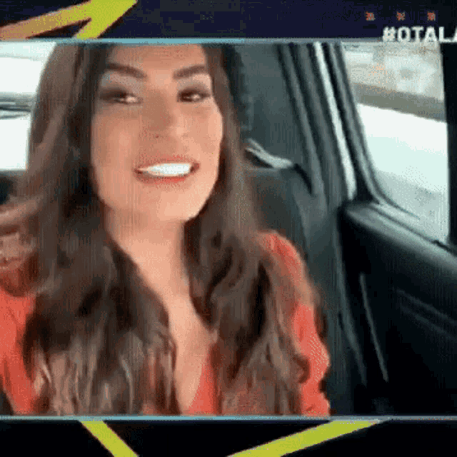 a woman is sitting in the back seat of a car and smiling