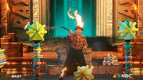 a man in a plaid shirt is performing a stunt with balloons on a stage with nbc written on the bottom