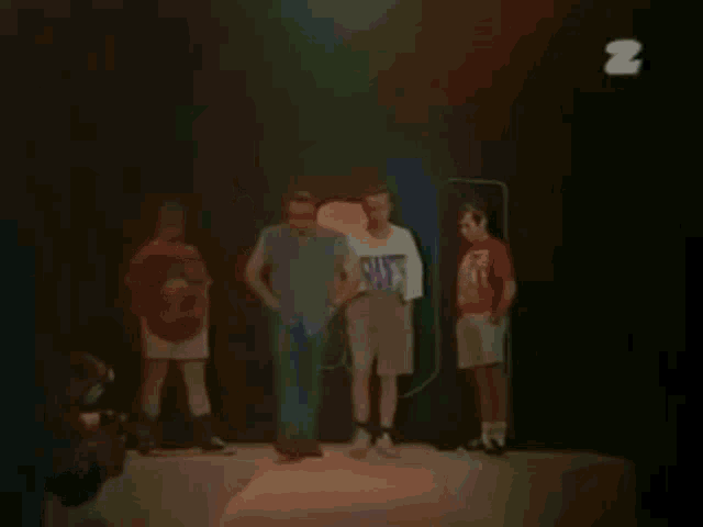 two men are standing next to each other and one of them is wearing a white shirt with the letter z on it .