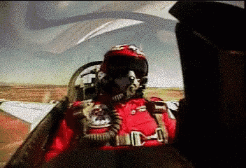 a man in a red suit is sitting in a cockpit