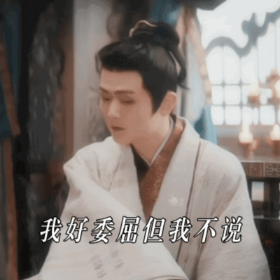a man in a white robe is reading a book with chinese writing on it