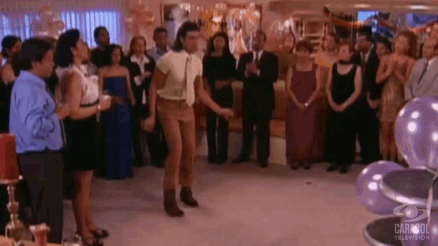 a man is dancing in front of a crowd of people at a party sponsored by carisol television