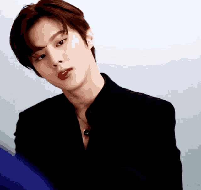 a young man wearing a black jacket and red lipstick