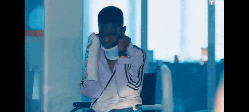 a man is sitting in a wheelchair with a bandage around his neck .