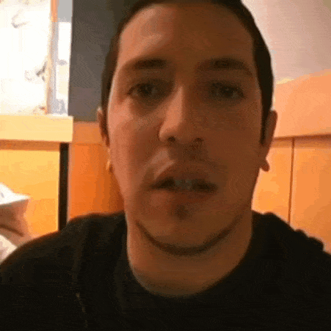 a close up of a man 's face with a slight smirk on his face .