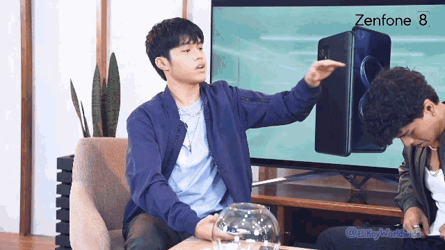 a man pointing at a zenfone 8 on a screen