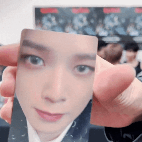a person is holding a card with a picture of a person 's face on it .