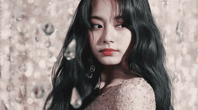 a close up of a woman with long black hair wearing a dress and earrings .