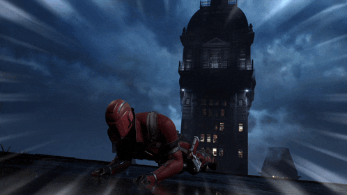 a man in a red suit is crawling on a roof
