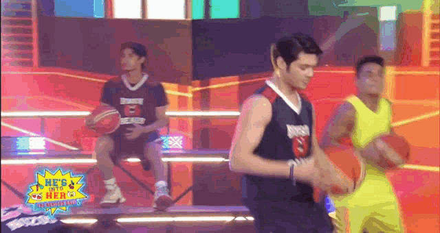 basketball players on a stage with a sign that says he 's a hero