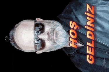 a man wearing sunglasses and a black jacket with the words hos geldiniz written on it