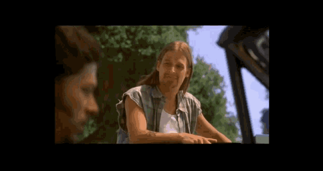 a man with long hair is sitting in a car with another man