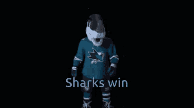 a sharks mascot standing in front of a black background with the words sharks win
