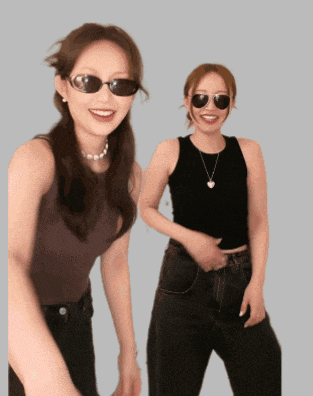two women wearing sunglasses and a necklace smile for the camera