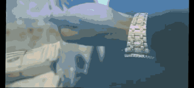 a blurred image of a person 's arm with a watch on it