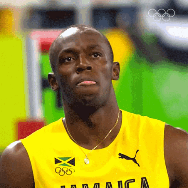 a man wearing a yellow jamaica tank top