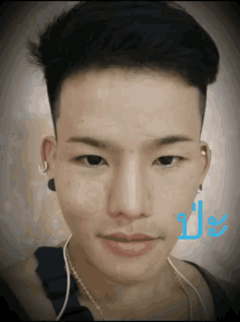 a close up of a man 's face with a blue letter l below it