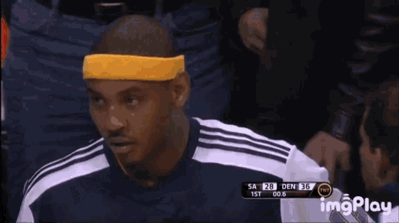 a basketball player wearing a yellow headband is sitting in the stands during a game