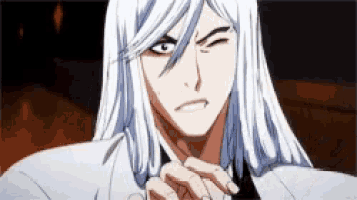 a man with long white hair is making a funny face while wearing a white suit and tie .