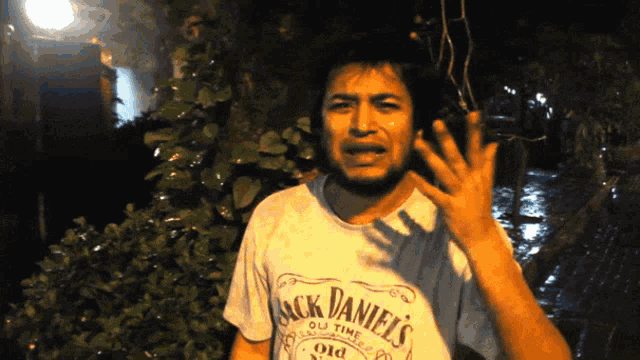 a man wearing a jack daniel 's shirt is making a funny face