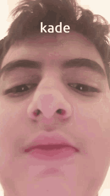 a close up of a man 's face with the word kade written above it
