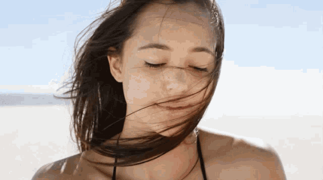 a woman 's hair is blowing in the wind