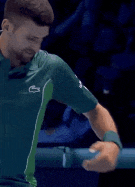 a man wearing a green shirt with a lacoste logo