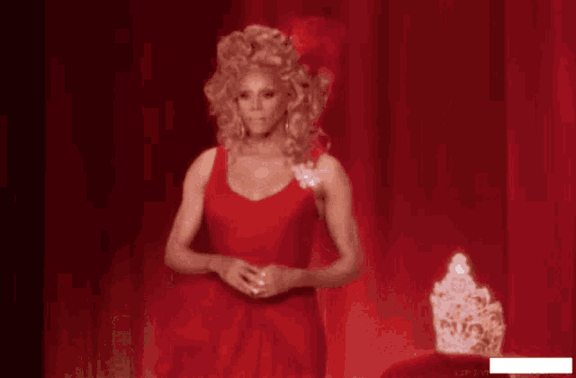 a woman in a red dress makes a heart with her hands