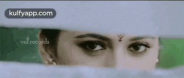 a close up of a woman 's eyes behind a white wall .