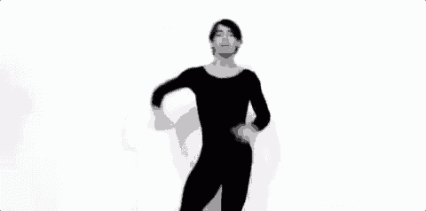 a black and white photo of a man in a black leotard dancing .