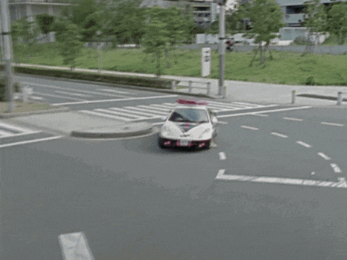 a police car is driving down a street with a red light on top of it