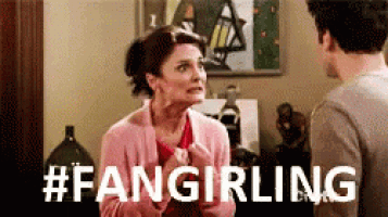a woman in a pink sweater is talking to a man in a living room with the words # fangirling written on the bottom