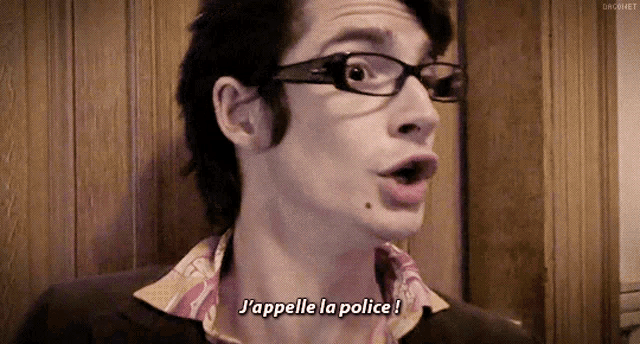 a man wearing glasses says " j'appelle la police " in french