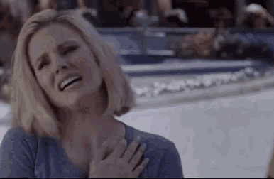 a woman is crying while holding her hand to her chest .
