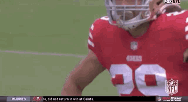 a football player wearing a 49ers jersey stands on the field